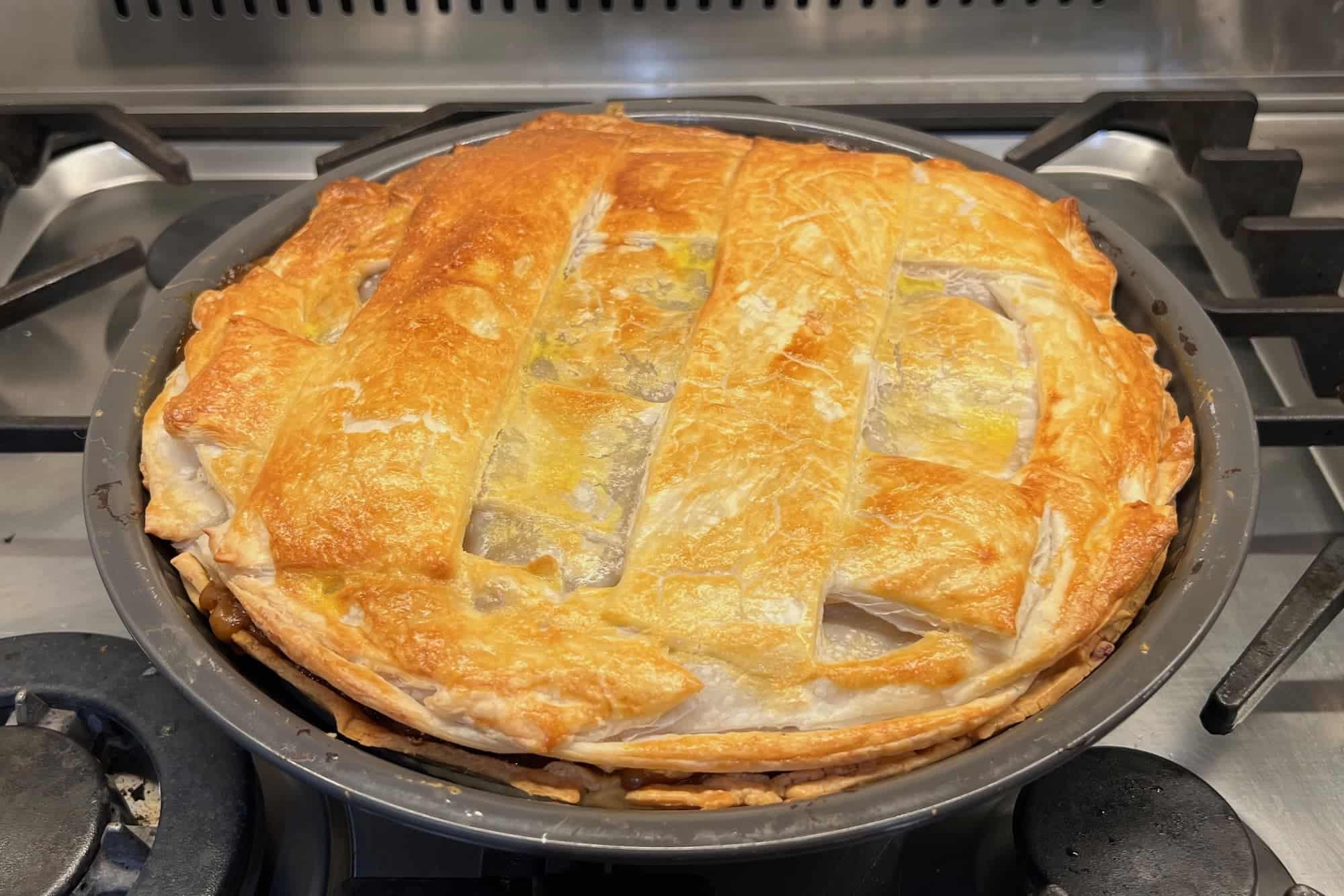 Family style Australian meat pie on stove